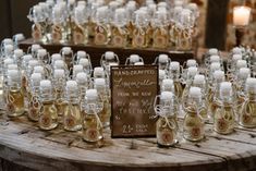 many small glass bottles are on a table with a sign that says handmade and labeled