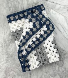 two crocheted dishcloths sitting on top of a marble counter