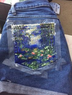 the back pocket of a pair of jeans with a painting on it