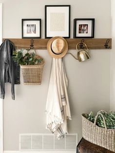 a coat rack with hats and other items hanging on the wall next to a bench