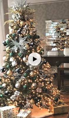 a christmas tree is decorated with silver and green ornaments, black and white baubies