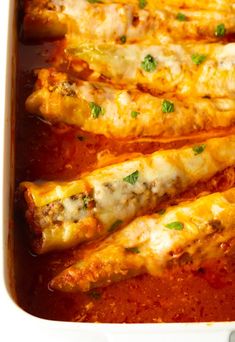 an enchilada dish is shown in a white casserole dish with meat and cheese