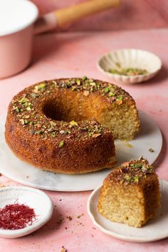 a bundt cake sitting on top of a white plate next to two small plates