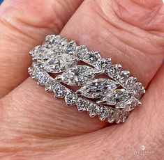 a woman's hand holding a diamond ring