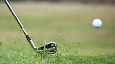 a golf ball is in the grass next to a driver's putt and club