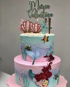 there is a multi layer cake decorated with mermaids