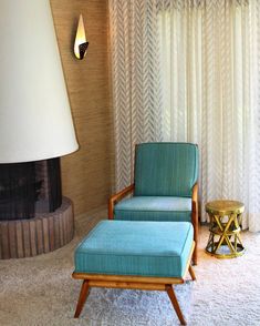 a living room with a chair, ottoman and lamp