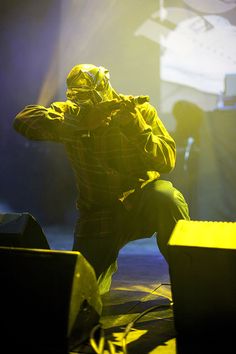 a man sitting on top of a stage with his hands to his face and head