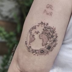 a woman with a tattoo on her arm that says girl power and flowers around the world