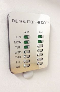 a white wall mounted to the side of a building with buttons on it that read, did you feed the dog?