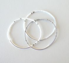 "Delicate combination of colors: the bracelets are a mix of gray white and silver beads. They are stretchy and comes in several sizes. Also choose yours at checkout. Perfect for any occasion. ❤ SIZES This item comes in several sizes. Kindly choose at checkout. The standard size for an average woman is 7\". For a child, a 6\" would be appropriate. I recommend you measure your wrist to determine the best fit. ❤ PROCESSING AND SHIPPING Most orders are made and shipped out in one business day. Pleas White Dainty Stackable Stretch Bracelet, Dainty White Stackable Stretch Bracelet, Delicate White Bracelets For Everyday Wear, Minimalist White Beaded Bracelets For Everyday, Dainty White Stretch Bracelet For Everyday, Everyday White Jewelry With Silver Beads, Dainty White Beaded Bracelets With Silver Beads, Dainty White Stretch Bracelet With Tiny Beads, White Beaded Bracelets