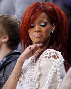 a woman with red hair sitting in a crowd