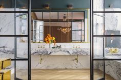 a bathroom with marble counter tops and gold accents on the walls, along with two sinks