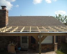 a house that is under construction with a roof made out of wood and metal beams