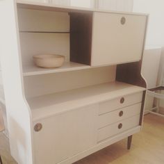 a white dresser with drawers and a bowl on top