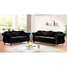 two black velvet couches in a living room