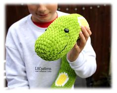 a young boy holding a green stuffed animal