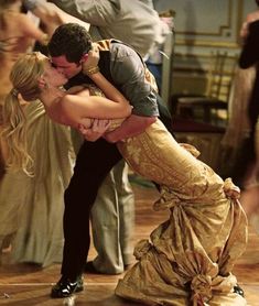 a man and woman are kissing on the dance floor