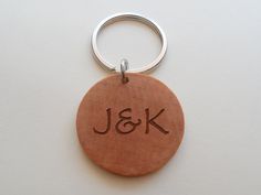 a wooden keychain with the initials j & k engraved on it's side