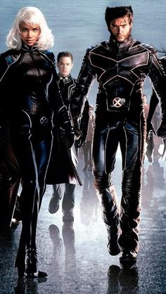 the x - men are walking down the street in leathers and catsuits