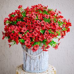 red flowers are in a bucket on a table