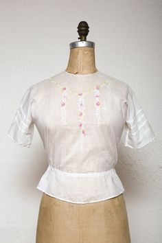 "USE COUPON CODE '25PERCENT' UPON CHECKOUT FOR YOUR DISCOUNT! Beautiful blouse semi sheer gauzy cotton.  Features lovely pink and chartreuse embroidered flowers, buttons down the back and drawstring waist. in excellent condition! may show general minor signs of age/use  Ready to wear! best fits size small: bust & waist fit 32-33\" // 84cm waist is \" // cm length from neck to hem is 19.5\" // 49.5cm * More info on our POLICIES page, here: https://www.etsy.com/shop/VeraVague/policy?ref=shopinfo_p Victorian Cotton Tops For Spring, Victorian Cotton Tops For Summer, Spring Victorian Cotton Tops, Spring Victorian Cotton Blouse, Fitted Cottagecore Blouse With Floral Embroidery, Cottagecore Fitted Blouse With Floral Embroidery, Fitted Vintage Tops With Floral Embroidery, Vintage Blouse With Floral Embroidery For Daywear, Fitted Short Sleeve Top With Yoke