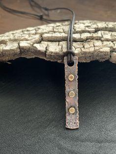 "This mixed metals pendant is hand textured and forged from pure organic copper. It has accents of celtic, gold brass and is finished with a rustic patina. Pendant is strung on a genuine cow hide brown leather necklace which is adjustable from about 24\" to 16\". It can be worn long or short. All jewelry from my studio has a lifetime craftsmanship guarantee. Your ring will arrive attractively packaged and ready for gifting or for keeps. MEASUREMENTS & SPECIFICS: SIZE: approx 2\" x .25\" THIC Hand Forged Brown Brass Necklace, Rustic Brown Hammered Jewelry, Hammered Brown Jewelry For Gift, Brown Hammered Jewelry As A Gift, Brown Hammered Jewelry For Gift, Hammered Bronze Copper Necklace, Bronze Hammered Copper Necklace, Rustic Hammered Bronze Jewelry, Rustic Hammered Gold Jewelry