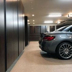 a car is parked in the middle of an empty parking garage with its door open