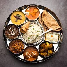 a plate with different types of food on it, including rice and vegetables in bowls