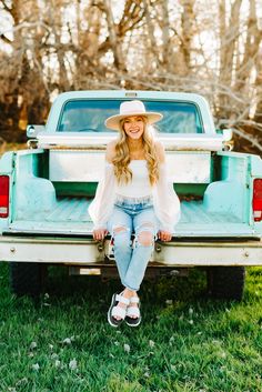 a woman sitting on the back of a pick up truck