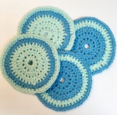 three crocheted blue and white coasters sitting on top of each other in the shape of circles