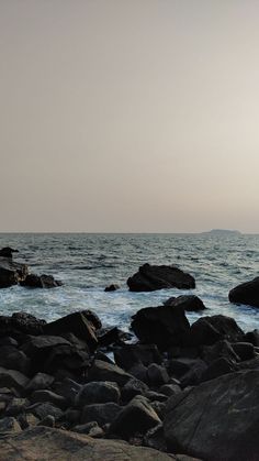 a person standing on rocks near the ocean