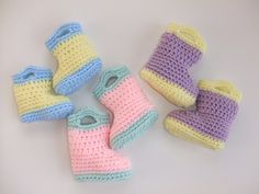 crocheted baby booties and boots are laying next to each other