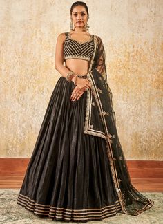 Our Black and Gold Embroidered Lehenga includes a satin top with santoon inner, satin bottom with santoon inner, and a net dupatta. Embroidery is present on this style using zari, sequins, and thread work.  Like all of our pieces, this piece is made in India and checked by hand to ensure high quality. Silk Embroidered Party Wear Choli, Silk Embroidered Choli For Party Wear, Party Wear Chanderi Choli With Resham Embroidery, Embroidered Silk Lehenga For Party, Silk Embroidered Lehenga For Party Wear, Party Wear Chanderi Choli With Zari Work, Silk Lehenga With Resham Embroidery For Party Wear, Party Wear Embroidered Lehenga In Raw Silk, Embroidered Raw Silk Party Wear Sets