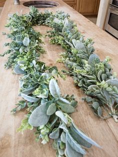 a wooden table topped with lots of plants on top of it's countertop