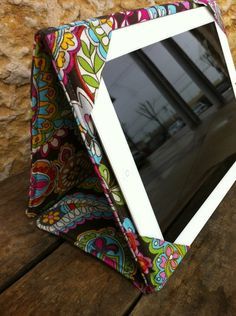 an ipad case sitting on top of a wooden table next to a stone wall and window