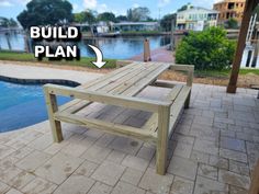 a wooden bench sitting on top of a brick patio next to a swimming pool with the words build plan above it