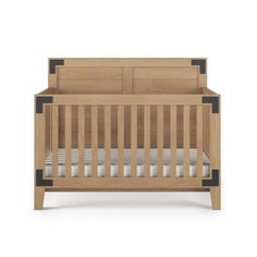 a wooden crib with white sheets and black trim