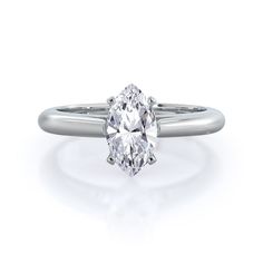 an oval cut diamond engagement ring on a white background, with the center stone set in 18k white gold