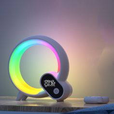 a colorful light sitting on top of a wooden table next to a white remote control