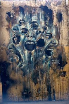 a painting on the side of a building that has been painted with multiple faces and mouths