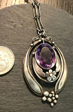 "Sterling  Amethyst handwrought studio Art Nouveau necklace.  Circa early 1900s.  Condition I see no problems any slight wear commensurate with age-pictures show design details.  Length of necklace 15\", more links can be added if desired, pendant drops from chain approx. 2\" by 1 1/8\", the oval faceted Amethyst is approx. 16mm by 12'' and bezel set.  Interesting construction -overlaid silver elongated  leaves give sweeping movement, with flower and abstract bead bubbles at base, graceful class Vintage Oval Gemstone Necklace, Formal Oval Art Nouveau Necklace, Oval Filigree Necklace In Art Nouveau Style, Antique Hallmarked Purple Necklace, Antique Purple Hallmarked Necklace, Antique Hallmarked Purple Necklaces, Antique Purple Hallmarked Necklaces, Antique Oval Necklace For Vintage Events, Vintage Purple Filigree Necklace