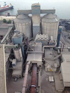 an aerial view of a large industrial building with pipes and tanks on the ground next to it