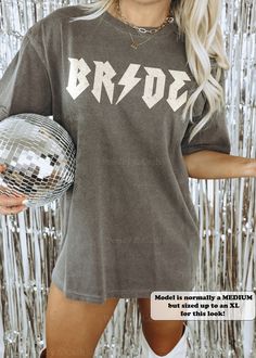 a woman posing with a disco ball in front of a tin foil background and the words,