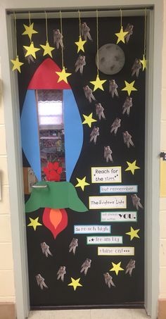 a door decorated with paper stars and an image of a rocket ship on the front