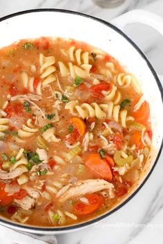 a bowl of chicken noodle soup with carrots, celery and noodles