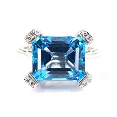 This ring is crafted in 18 Karat white gold and features an emerald cut blue topaz. The blue topaz totaling approximately 5 Carats is accented by 58 round diamonds of VS Clarity and H Color totaling 0.58 Carats. Finger size 8.5, Jae's Jewelers includes a free ring sizing on all rings that can be sized at check out. Topaz And Diamond Ring, Emerald Cut, Blue Topaz, Round Diamonds, Topaz, Diamond Ring, Emerald, Ring Size, Diamonds