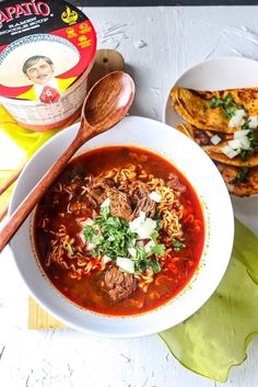 a bowl of soup next to some tortilla bread