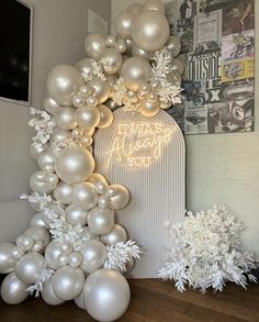 white balloons and snowflakes are arranged in the shape of an arch