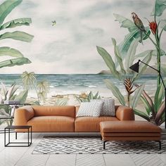 a living room scene with a couch and tropical wall mural on the wall behind it